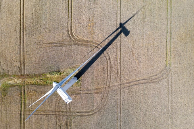 aerial-view-wind-turbine-brown-fields_675x450